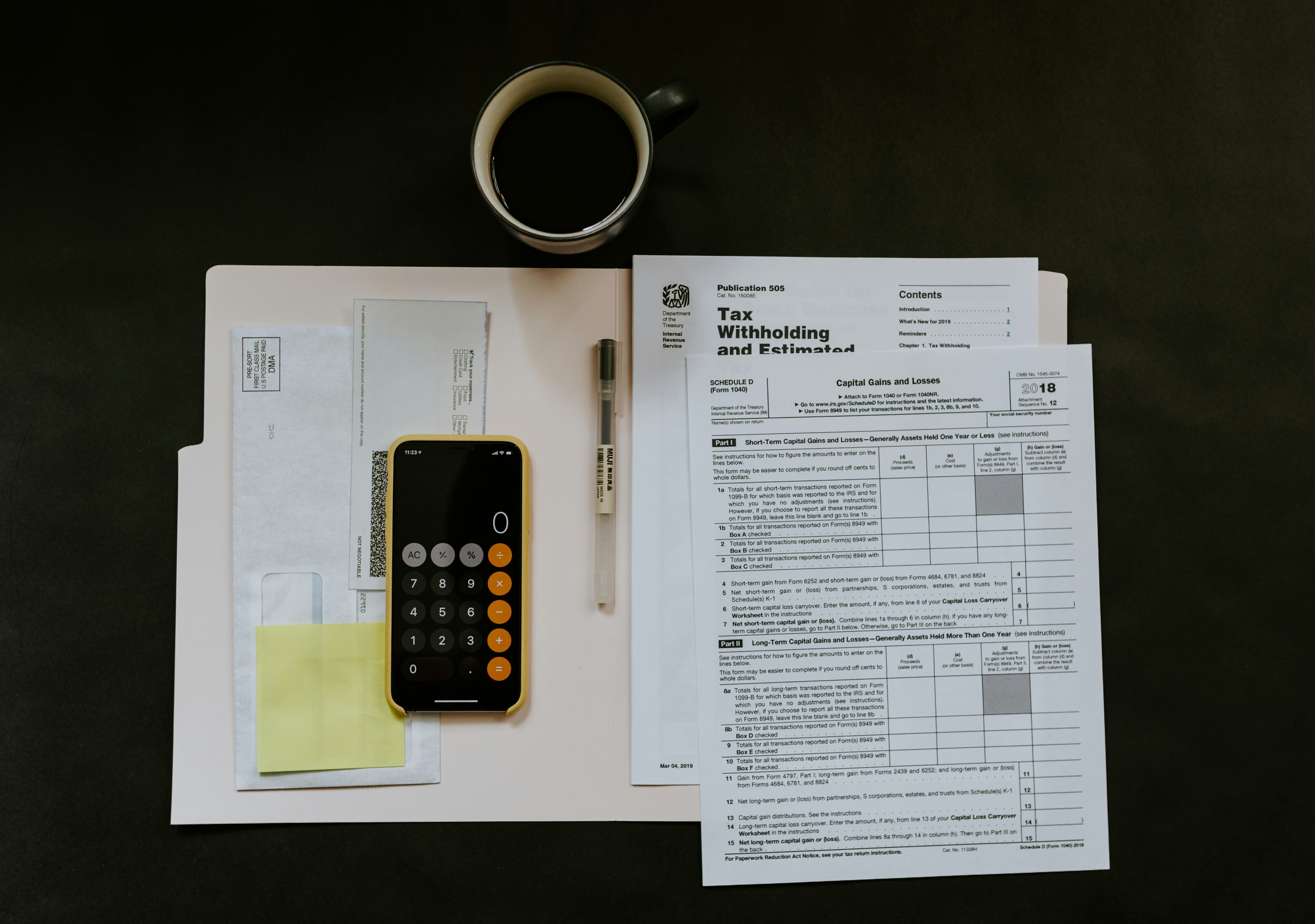 Tax withholding certificate and pen on a folder, illustrating real estate depreciation tax benefits syndication investors report on a K-1