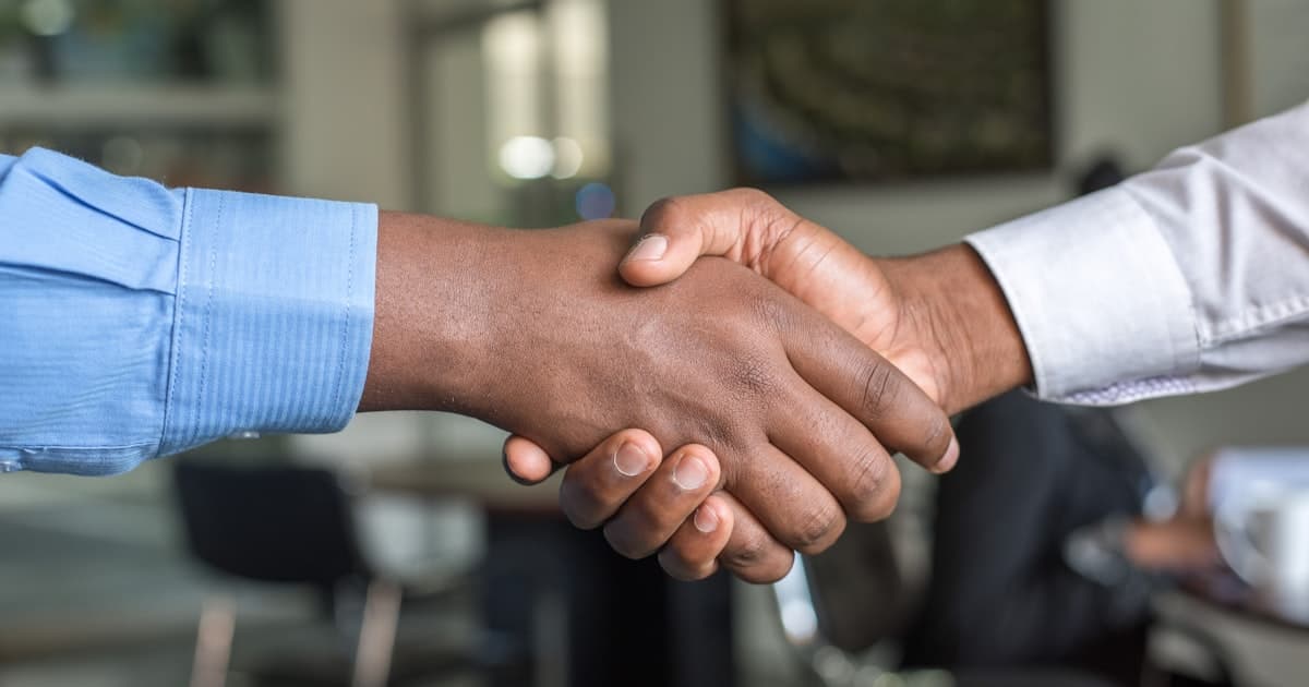Professional handshake closing a real estate syndication deal